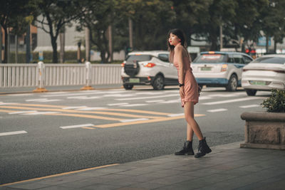 Full length of young woman walking on street