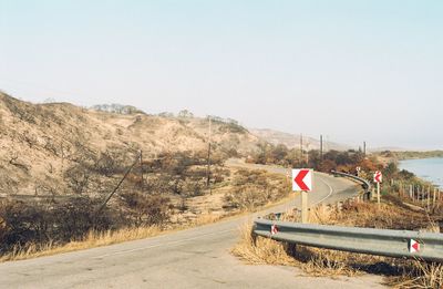 Road by mountain against clear sky