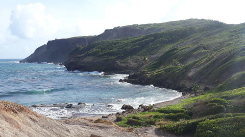 Scenic view of sea and mountains against sky