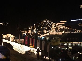 Illuminated bridge over canal in city at night