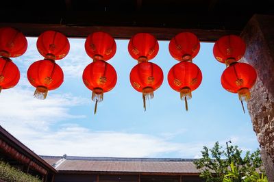 Low angle view of lanterns hanging ceiling against sky