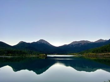 Scenic view of lake and mountains against clear sky