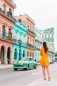 Rear view of woman standing on street in city