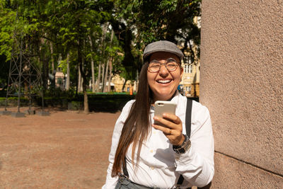 Portrait of smiling young woman using mobile phone