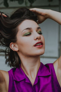 Close-up of young woman with hand in hair