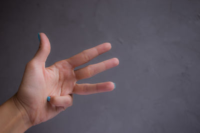 Close-up of woman gesturing over gray background