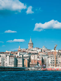 Buildings by sea against sky