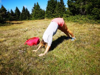 Full length of woman exercising on grassy field