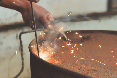 Cropped hands welding metal at workshop