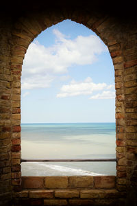 Scenic view of sea seen through arch