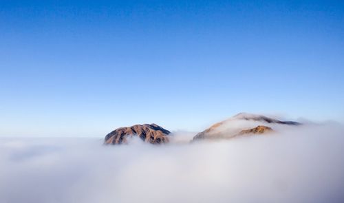 Scenic view of snowcapped mountains against clear blue sky