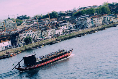 Scenic view of river by buildings against clear sky