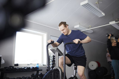 Man exercising on gym bike at health club