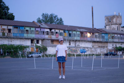 Full length rear view of woman standing against building