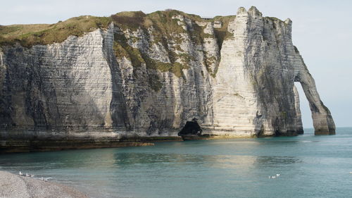 Panoramic view of sea by rock formation against sky