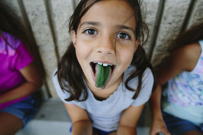 Portrait of girl showing green candy colored tongue