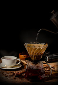 Coffee cup on table against black background