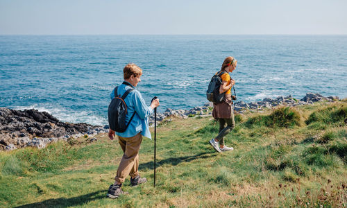 Grandmother and adult granddaughter trekking along the coast