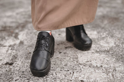 Low section of person wearing shoes standing on road