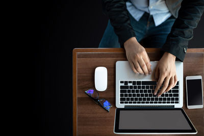 Midsection of man using laptop on table