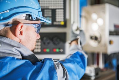 Close-up of man using machinery at factory