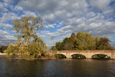 Arch bridge over river against sky