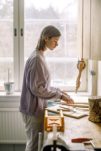 Side view of female teenage student practicing during carpentry class