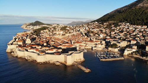 High angle view of townscape by sea against sky