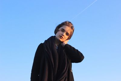 Portrait of young woman against clear sky