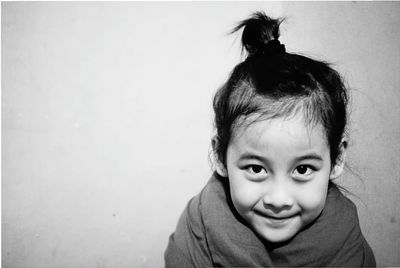 Portrait of smiling girl against wall