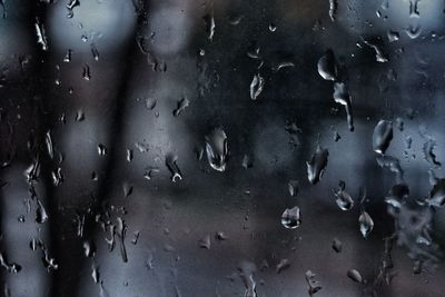 Close-up of water drops on snow against sky