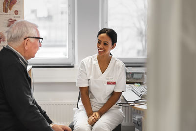 Smiling doctor talking with patient in office