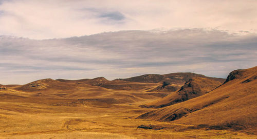 View of desert against cloudy sky