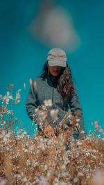 Woman standing against blue sky