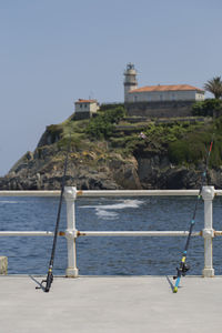 Sailboat on sea by building against clear sky