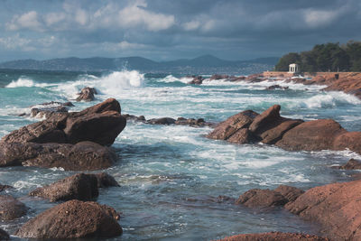 Scenic view of rocks in sea against sky