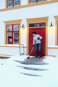 Woman removing snow from porch