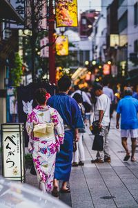 Rear view of people walking on street