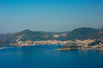 Scenic view of sea and mountains against blue sky