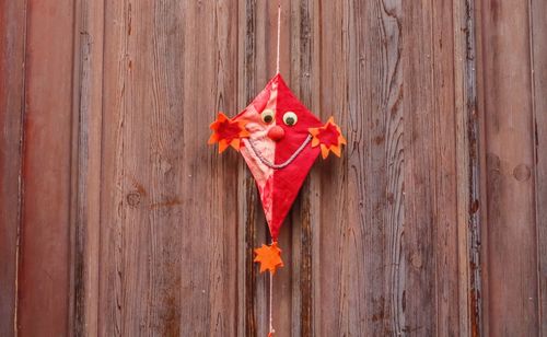 Close-up of small kite hanging on wooden wall