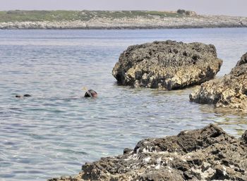 Scenic view of rocks in sea against sky - snorkeling