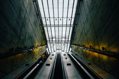 Low angle view of people on escalators in subway station