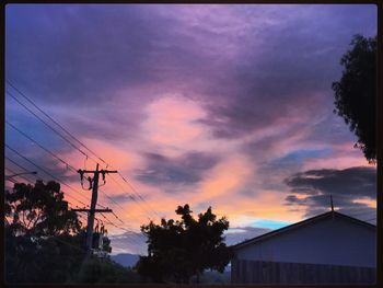 Low angle view of silhouette houses against dramatic sky