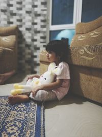 Full length of young woman sitting on sofa