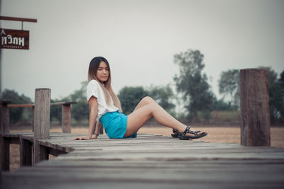 Young woman sitting on wooden floor