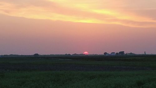 Scenic view of field against sky during sunset