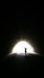 Silhouette man standing in tunnel