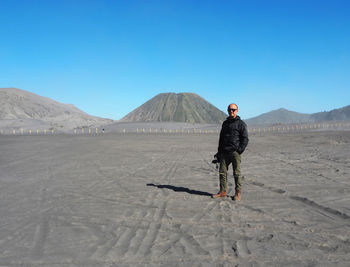 Full length of man on arid landscape against clear sky