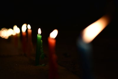 Close-up of lit candles in darkroom