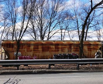 View of railroad tracks and bare trees against sky